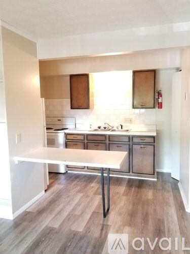 A kitchen with a white table and wooden cabinets.