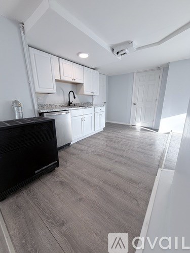 A kitchen with white cabinets and a black countertop.