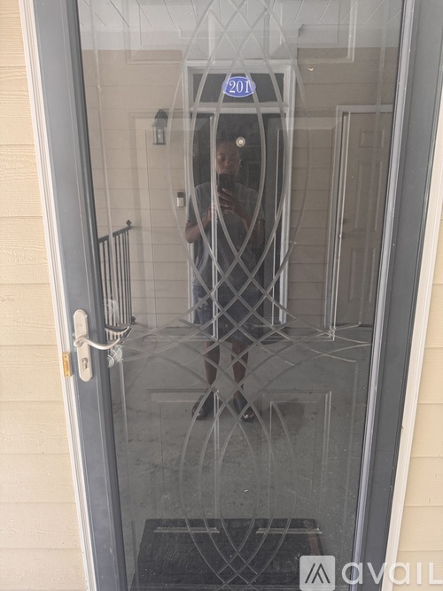 A person is standing in a glass door with a sign that says "20" on it.