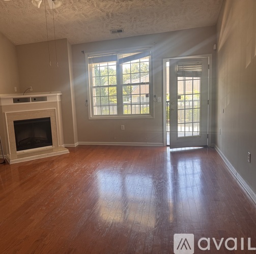 A living room with a fireplace and wood flooring.