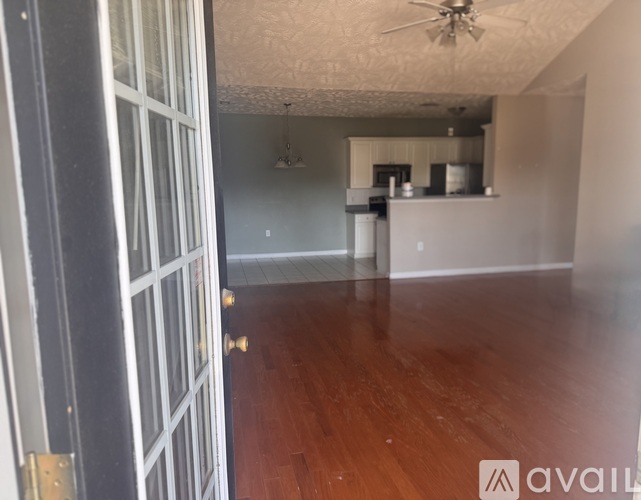 A room with wooden floors and a ceiling fan.