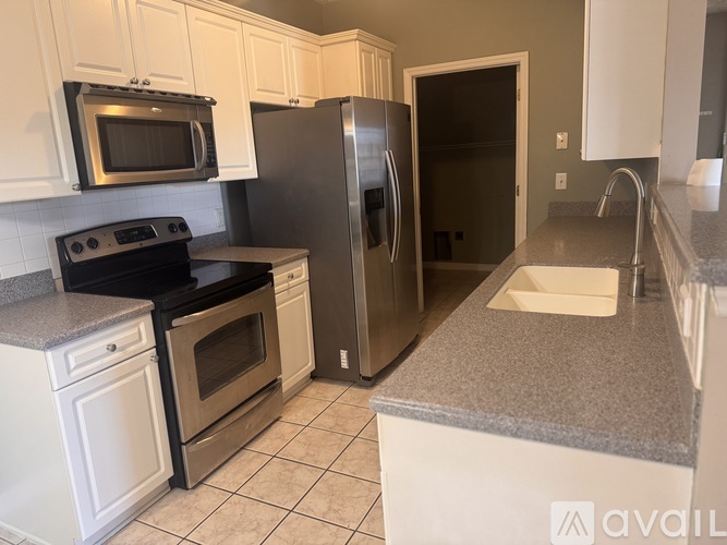 A kitchen with white cabinets and a black stove top oven.
