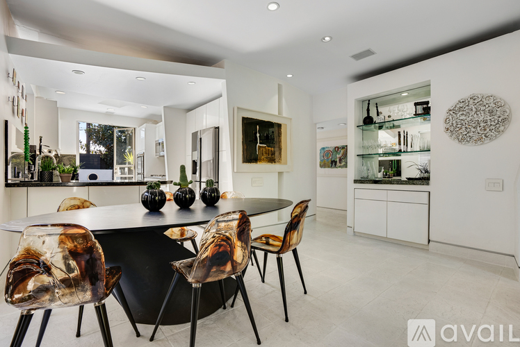 A modern dining room with a black table and chairs.