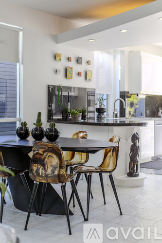 A modern kitchen with a black table and chairs.