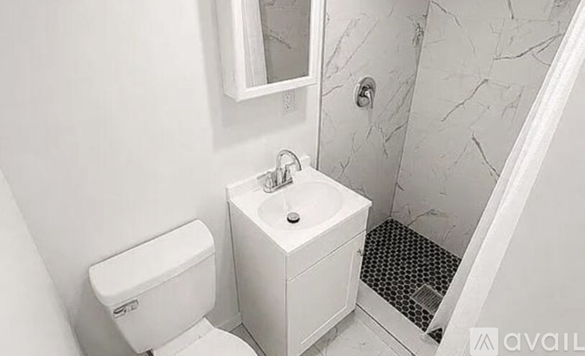 A white toilet sits next to a white sink in a bathroom.
