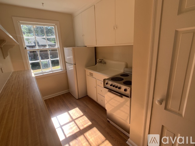 A kitchen with white appliances and wooden floors.