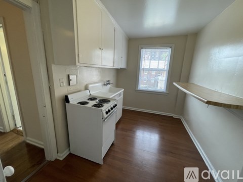 A small kitchen with a stove top oven and a window.