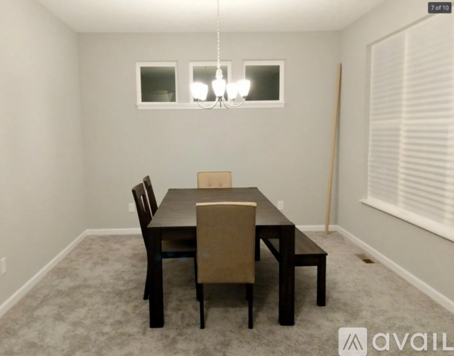 A dining room with a table and chairs.