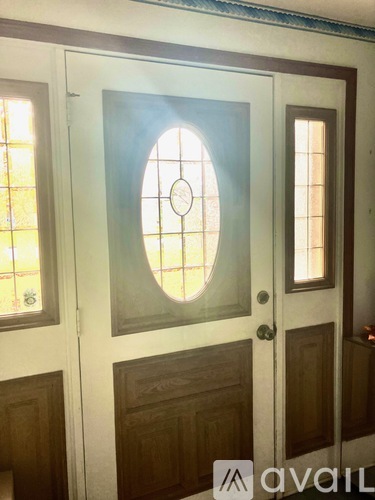 A white door with a circular window in the middle and two smaller windows on the sides.
