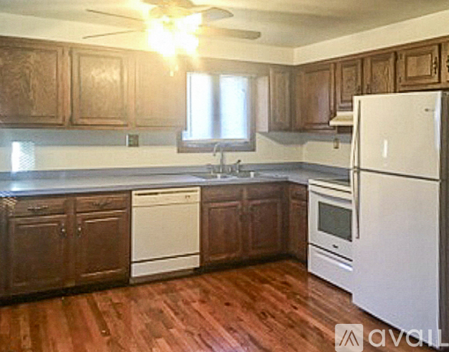 A kitchen with wooden cabinets and a white fridge.