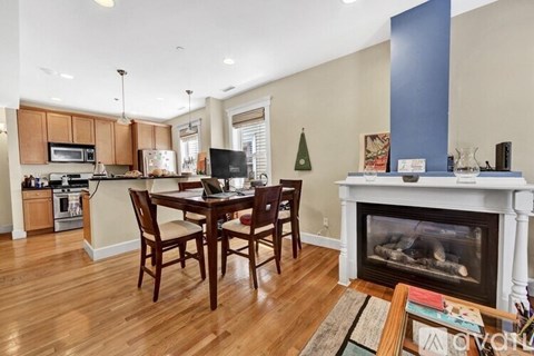 A kitchen with a dining table and chairs in front of a fireplace.