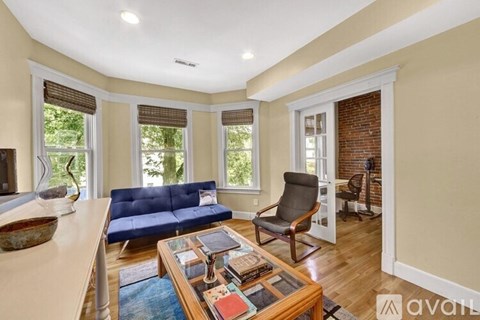 A living room with a blue sofa and a wooden coffee table.
