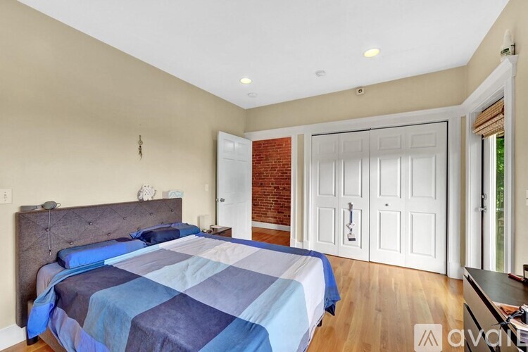 A bedroom with a bed and a brick wall.