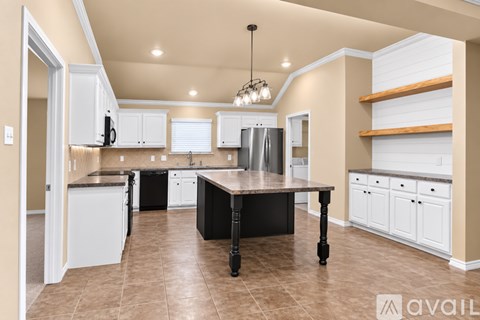 A kitchen with a black table and white cabinets.