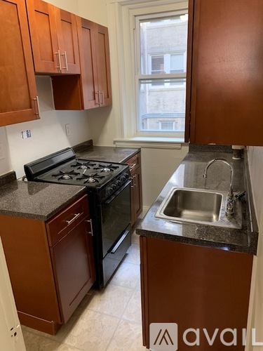 A kitchen with brown cabinets and a black stove top oven.