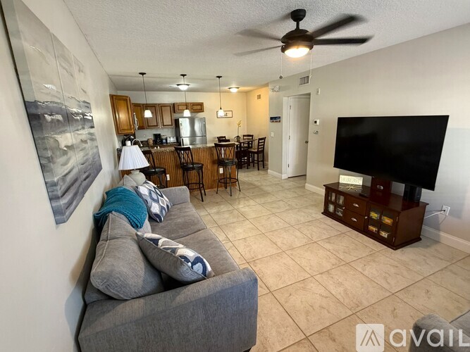 A living room with a grey couch and a black television.