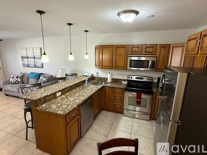 A kitchen with wooden cabinets and granite countertops.