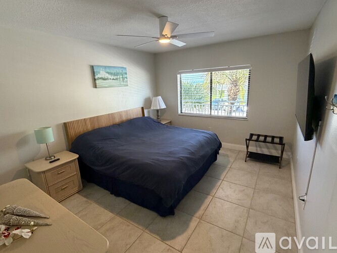 A bedroom with a bed, nightstand, and window.