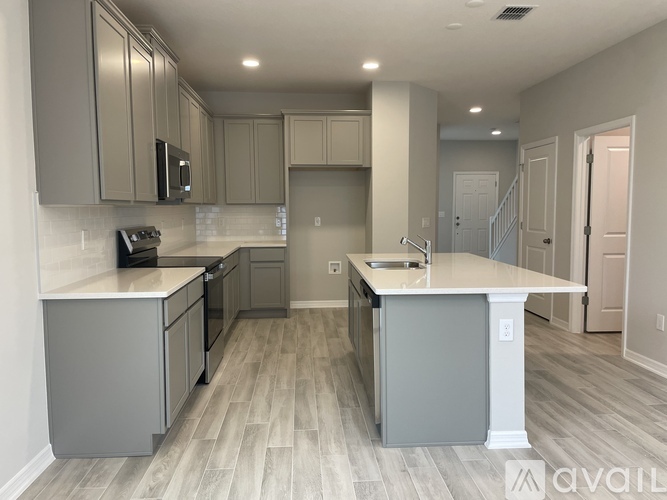 A kitchen with a white countertop and grey cabinets.