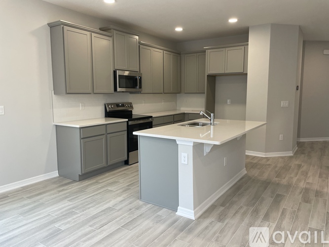 A kitchen with a white countertop and grey cabinets.
