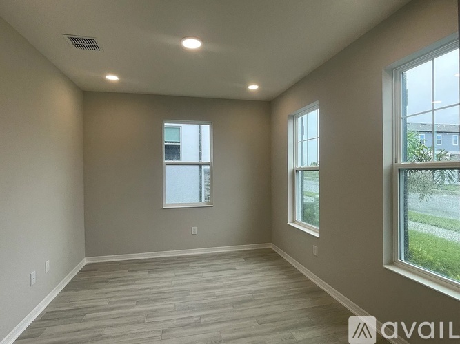 A spacious room with two windows and a tiled floor.