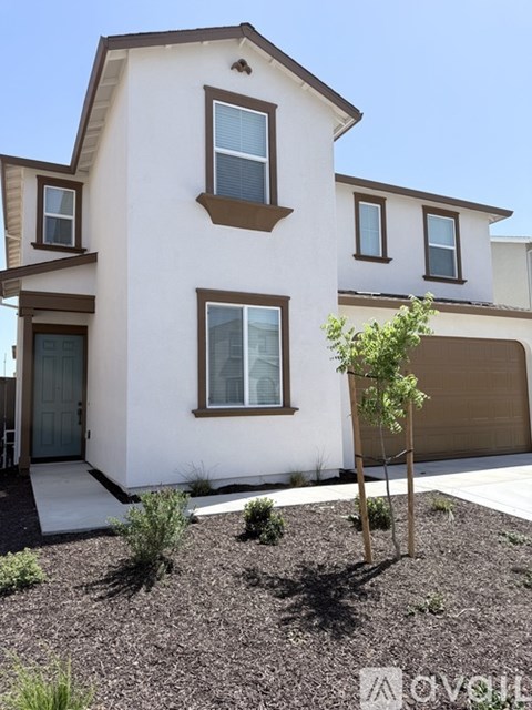 A white house with brown trim and a brown garage door.