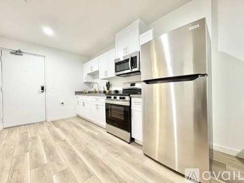 A kitchen with a stainless steel refrigerator, oven, and microwave.