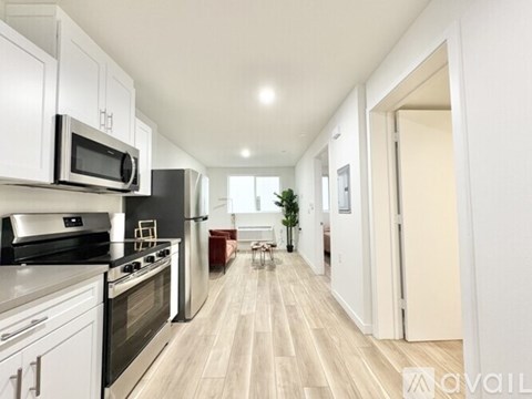A modern kitchen with white cabinets and stainless steel appliances.