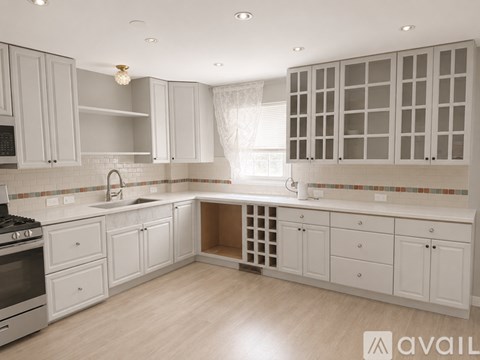 A kitchen with white cabinets and a tiled backsplash.