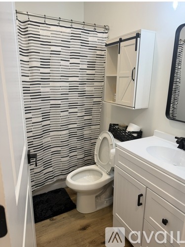 A bathroom with a toilet, sink, and a towel rack.