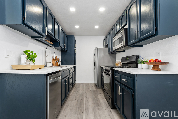 A kitchen with dark blue cabinets and stainless steel appliances.