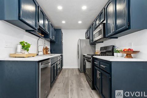 A kitchen with dark blue cabinets and stainless steel appliances.