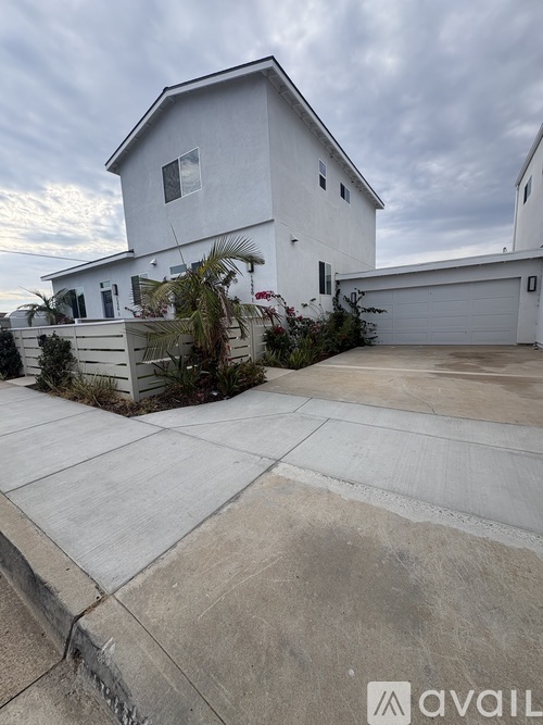 A white house with a driveway in front.