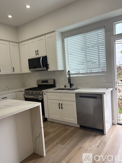 A kitchen with white cabinets and a black stove top oven.