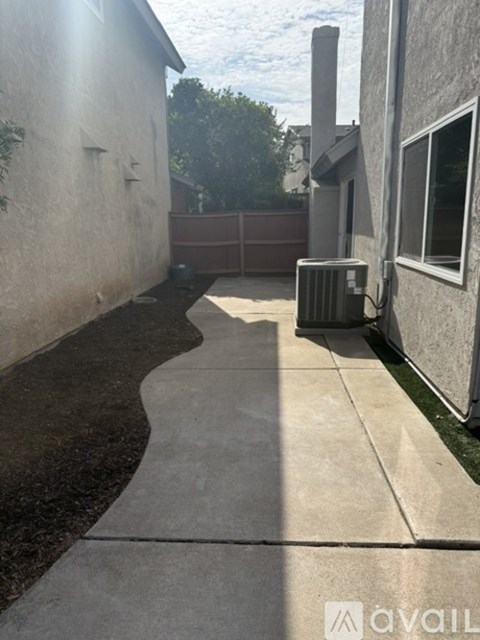 A concrete pathway leads from a building to a gate.