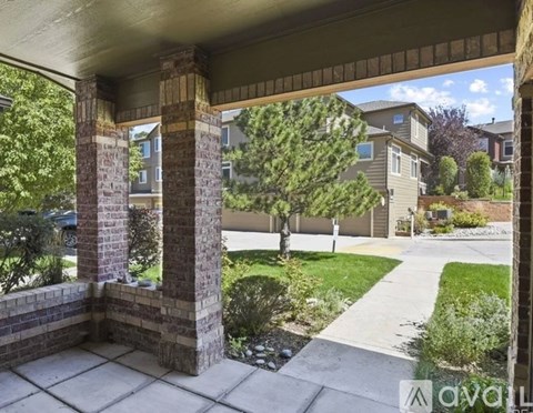 A view from a covered patio looking out to a residential street.