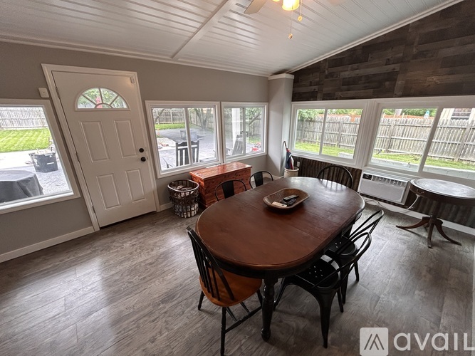 A dining room with a wooden table and chairs.