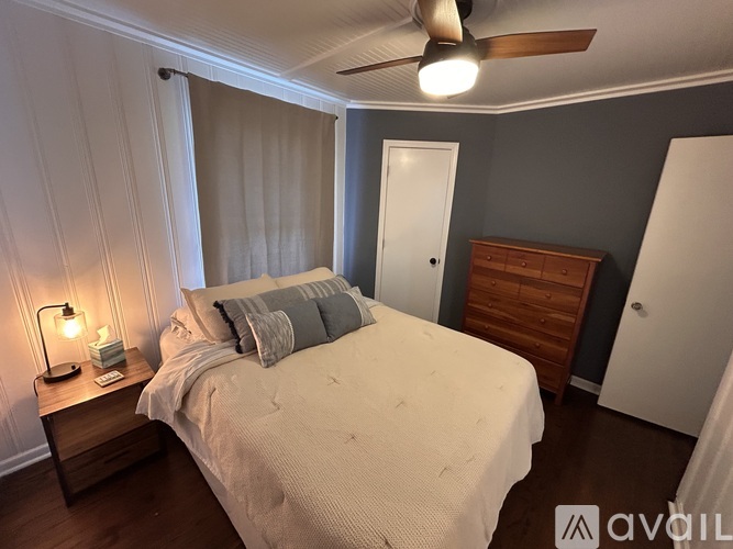 A bedroom with a bed, nightstand, and a ceiling fan.