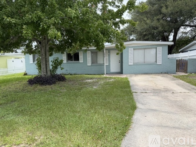A house with a green lawn and a tree in front.
