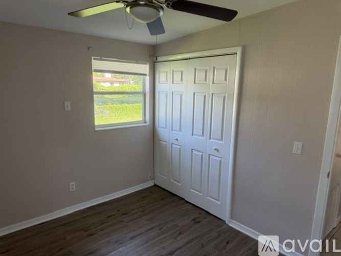 A room with a ceiling fan and a door leading to a backyard.