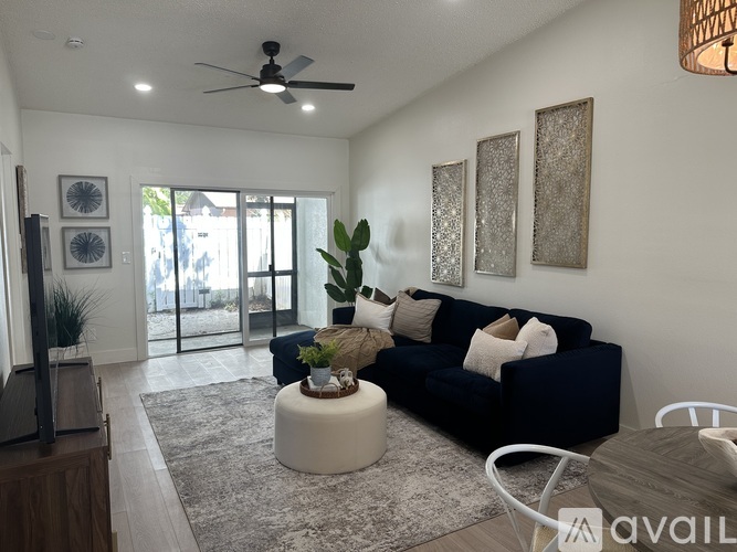 A living room with a dark blue couch, a white coffee table, and a ceiling fan.