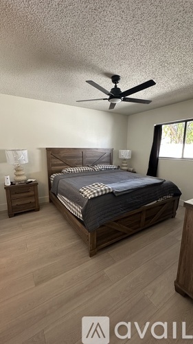 A bedroom with a bed, nightstand, and a ceiling fan.