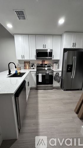 A kitchen with white cabinets and a refrigerator.
