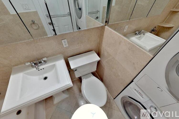 A bathroom with a toilet, sink, and mirror.