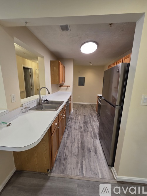 A kitchen with a white counter top and wooden cabinets.