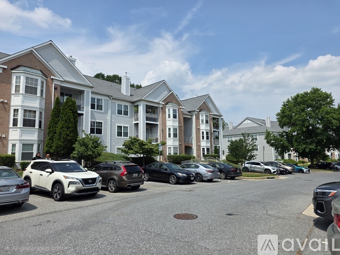 A row of cars parked in front of apartment buildings.