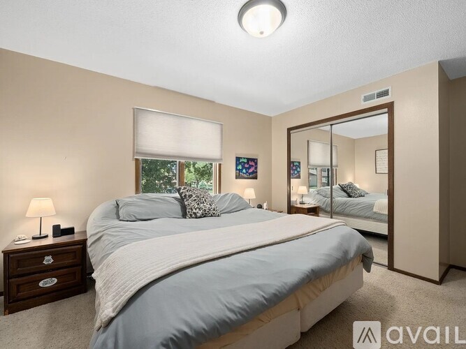 A bedroom with a large bed and a mirror on the wall.