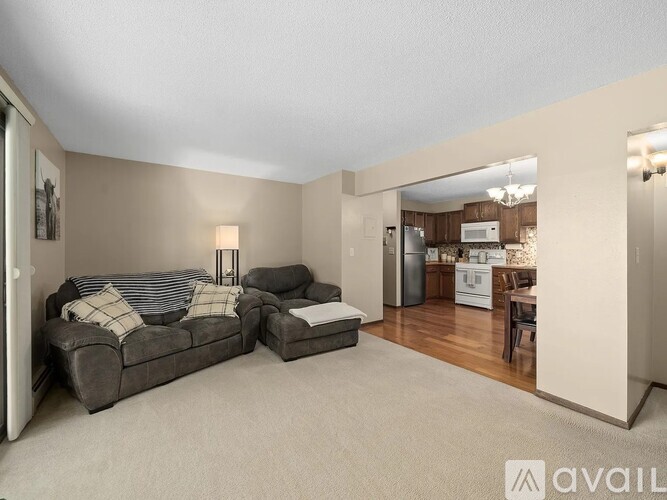A living room with a grey couch and a lamp on the side table.