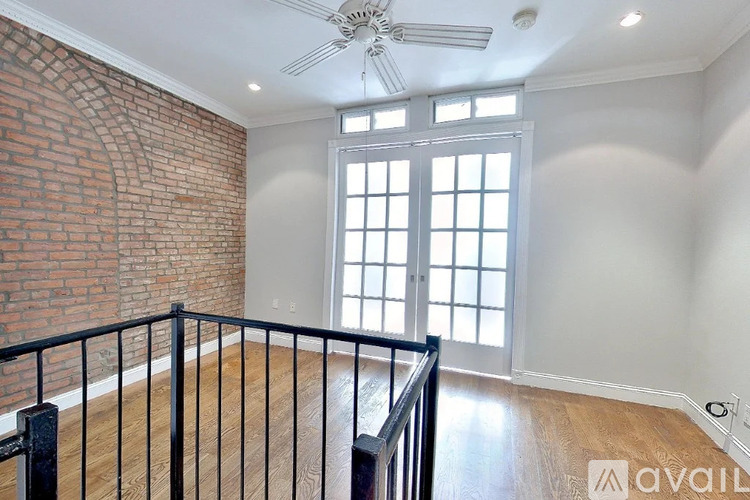 A room with a brick wall and a wooden floor.