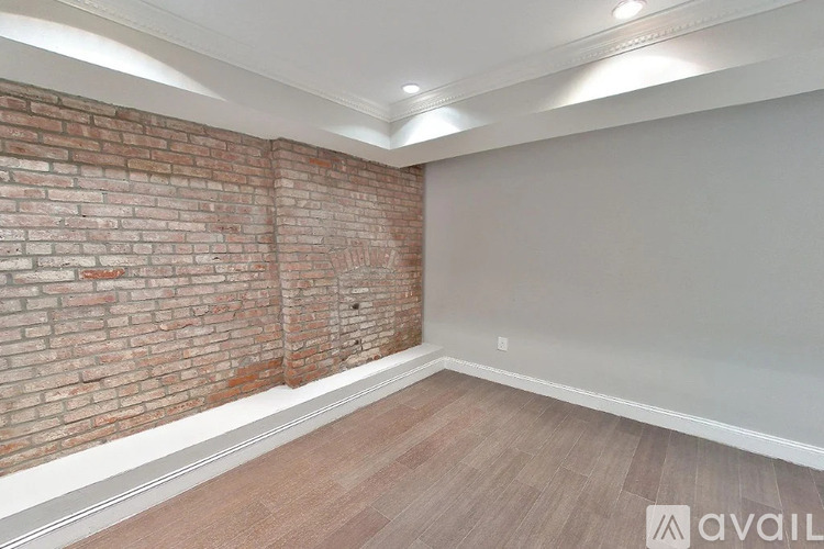 A room with a brick wall and wooden flooring.